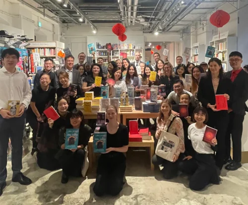 A group of people in a bookstore, holding books in their hands